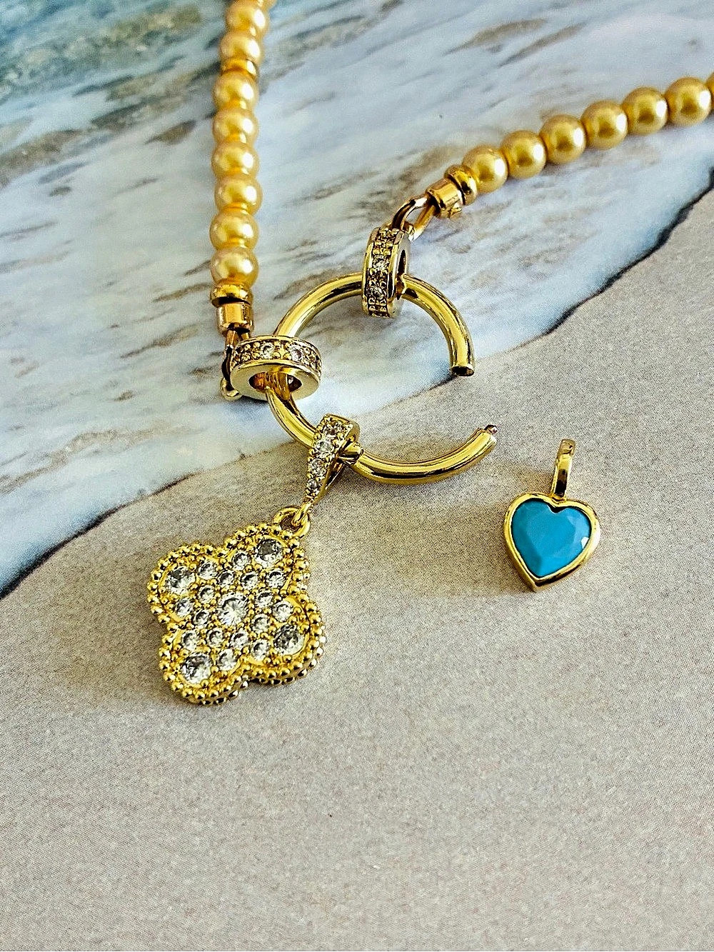 Gold-Tone Flower Pendant Necklace with Lobster Clasp and Blue Heart Charm. The c